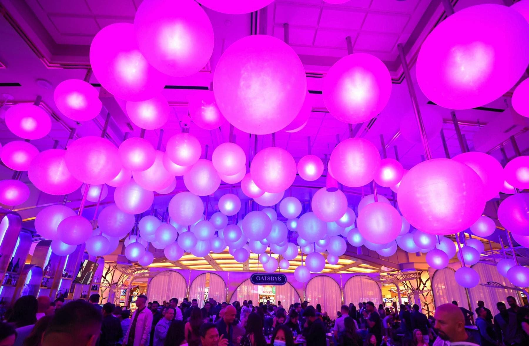 Crowd at Gatsby’s with the oval lounge sign and purple lighting